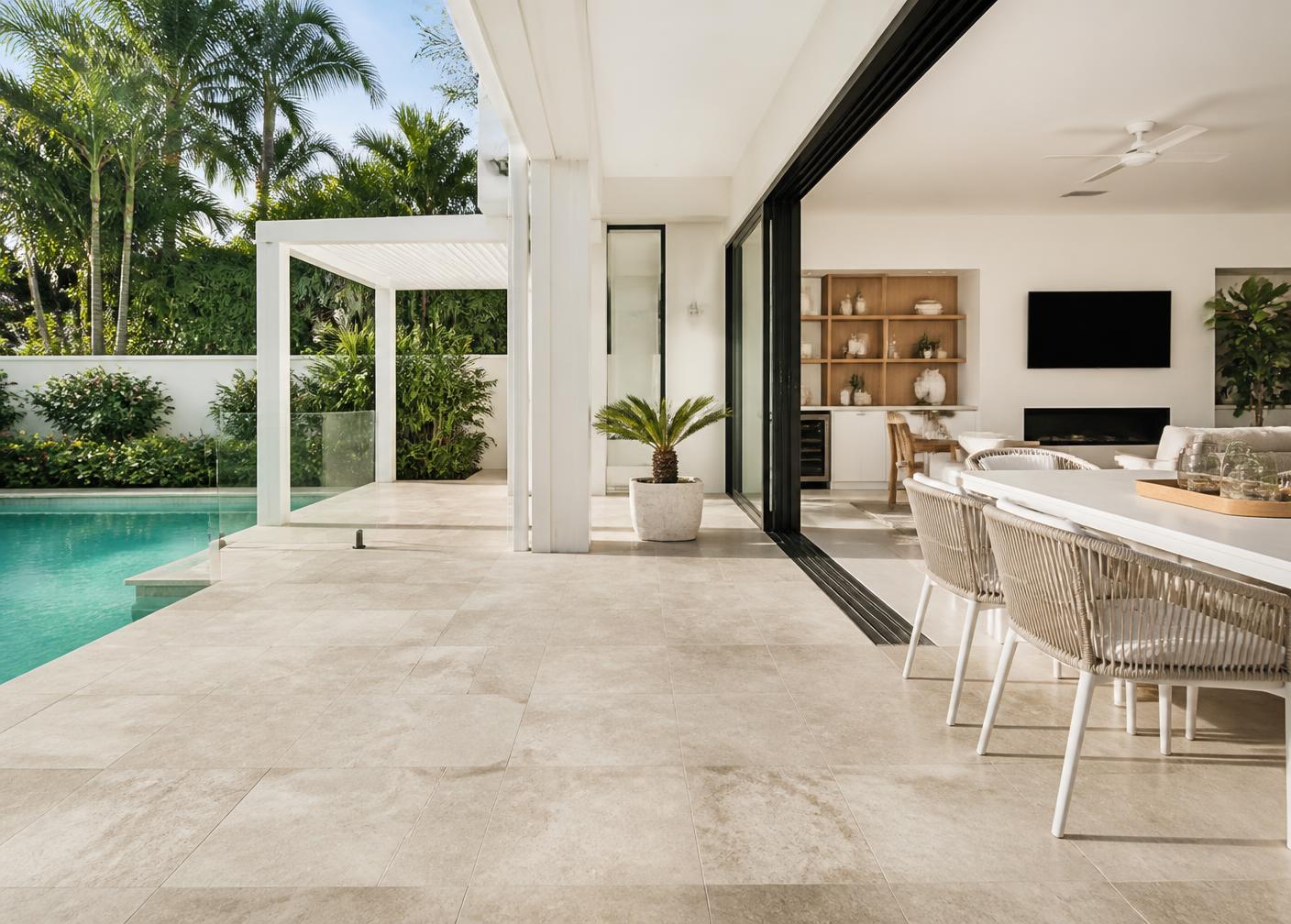Alfresco terrace tiled in large-format stone-look pavers beside a pool